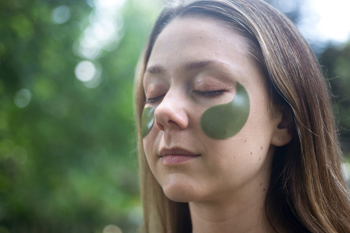 Woman outdoors with eyes closed wearing eye patches